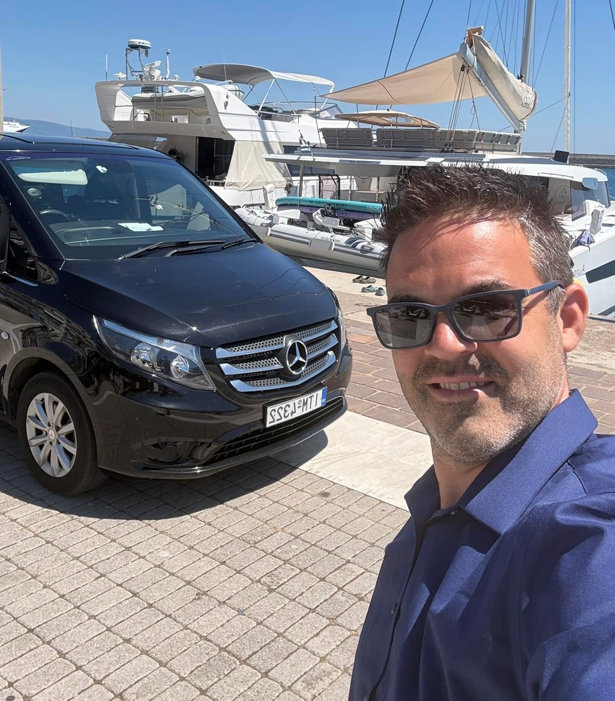 Dionysis Barounis, founder of We Transfer You, beside a Mercedes vehicle